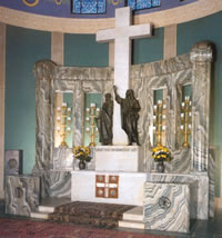 Altar mit weißem Marmorkreuz und zwei Figuren